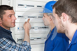 Tradesmen showing apprentices fuse board