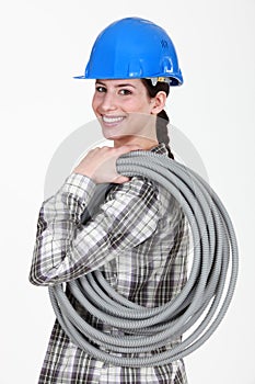 Tradeswoman carrying corrugated tubing