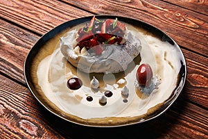 Tradicional Pavlova cake and ice cream served on plate