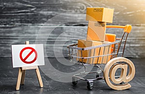 Trading cart with boxes and an easel with a prohibition symbol NO. Internet trade online shopping ban. Restriction on importation