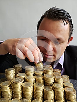 economic growth, young businessman stacking mexican coins of ten pesos