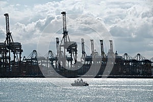 Trading seaport with cranes, cargoes and the ship Singapore