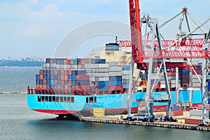 The trading seaport with cranes, cargoes and ship