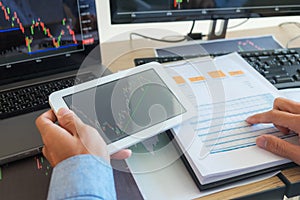 Trading on the table is working on a computer screen full of charts and data analysis and stock trading through online brokers