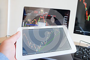 Trading on the table is working on a computer screen full of charts and data analysis and stock trading through online brokers