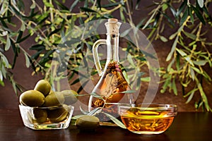 Tradition Crete flavored olive oil with spieces rosemary and pepper in local vial, with olives, and olive leafs on wooden backgrou