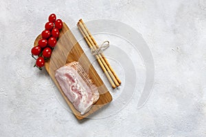 Tradition  Pancetta bacon served with pickled olives, tomatoes and grissini bread, popular antipasto food. Close up, top view on