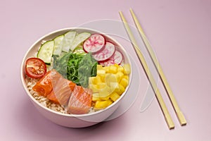 Traditiona Hawaiian red fish poke bowl with rice, radish,cucumber, tomato, and seaweeds. Buddha bowl. Diet food. Flat lay. Bamboo