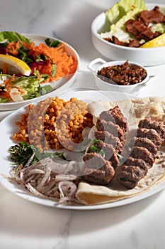 Traditional Adana Kebap with salad on white