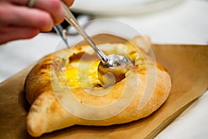 Traditional Adjara khachapuri. In a boat of dough baked cheese,