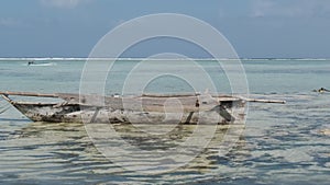 Traditional African Fishing Boat Stranded in Sand on Beach at Low Tide, Zanzibar