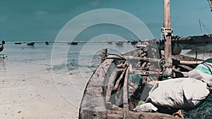 Traditional African Fishing Boat Stranded in Sand on Beach at Low Tide, Zanzibar