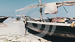 Traditional African Fishing Boat Stranded in Sand on Beach at Low Tide, Zanzibar