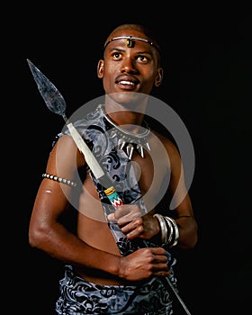 Traditional African Xhosa prince holding a traditional beaded handmade spear.