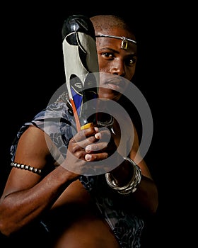 Traditional African Xhosa prince pose with a traditional colourful African wooden mask.