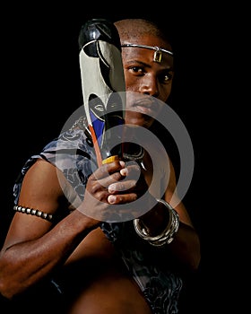 Traditional African Xhosa prince pose with a traditional colourful African wooden mask. photo