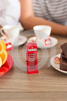 Traditional afternoon tea of british ceremony with such symbol of britishness as toy telephone box