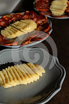 A traditional Alentejo sausage, known as paio, sliced and displayed alongside a rustic cheese wheel on a white plate. photo