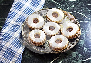 Traditional algerian cookies with apricot jam in plate on marble table.