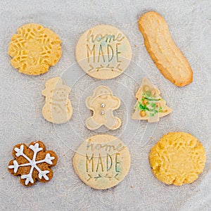 Traditional almond cookie with sugar, spices, and vintage rolling pin on rustic, on natural linen background.