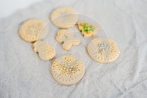 Traditional almond cookie with sugar, spices, and vintage rolling pin on rustic, on natural linen background.