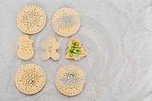 Traditional almond cookie with sugar, spices, and vintage rolling pin on rustic, on natural linen background.