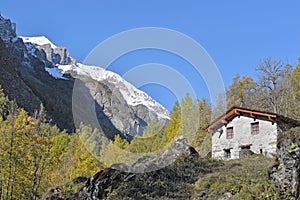 Traditional alpine cottage in mountain landscape under blue sky