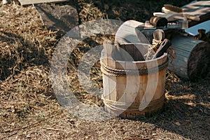 Traditional ancient russian wooden water bucket stands on the ground in summer, selective focus.