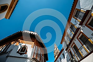 Traditional Andalucian architecture with Bell Tower of La Mezquita, Cordoba, Spain