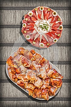 Traditional Appetizer Savory Welcome Dishes Served on Rustic Crinkly Interlaced Paper Parchment Place Mat Vignette Background