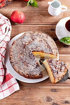 Traditional apple pie on a white plate on a table. Charlotte pie on a platter. Delicious homemade pastry on the kitchen table. Top