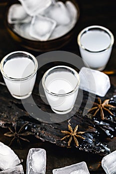 Traditional arabic alcohol drinks Raki with anise, rustic wooden background with space for text