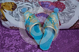 Traditional Arabic blue shoes . Arabian oriental blue shoes in the Aladdin style . on white beech. pink background . Arabian