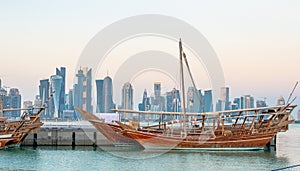 Traditional Arabic Dhow boats along with Doha skyline