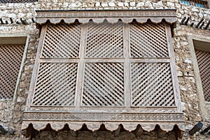 Traditional Arabic mashrabiya balcony enclosed with carved wood latticework photo