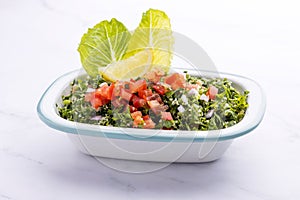 Traditional Arabic Salad Tabbouleh isolated on a marble backdrop