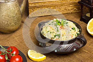 Traditional Arabic salad or Tabbouleh in vintage bowl, healthy vegetarian dish with couscous, tomatoes, parsley, mint