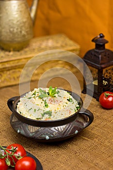 Traditional Arabic salad or Tabbouleh in vintage bowl, healthy vegetarian dish with couscous, tomatoes, parsley, mint