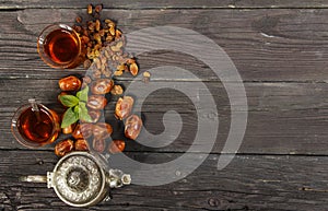 Traditional Arabic, Turkish Ramadan tea with dry dates and raisins on a wooden black table. Ramadan. Turkish fresh tea with dates.