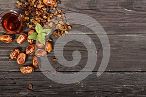 Traditional Arabic, Turkish Ramadan tea with dry dates and raisins on a wooden black table. Ramadan. Turkish fresh tea with dates.