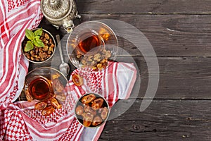 Traditional Arabic, Turkish Ramadan tea with dry dates and raisins on a wooden black table. Ramadan. Turkish fresh tea with dates.