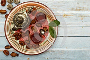 Traditional Arabic, Turkish Ramadan tea with dry dates and raisins on a wooden white table. A cup of tea on a white table.Turkish