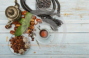 Traditional Arabic, Turkish Ramadan tea with dry dates and raisins on a wooden white table. A cup of tea on a white table.Turkish