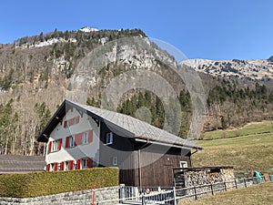 Traditional architecture and farmhouses in the alpine valley of KlÃ¶ntal or Kloental and by the resevoir lake KlÃ¶ntalersee