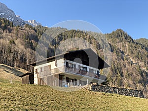 Traditional architecture and farmhouses in the alpine valley of KlÃ¶ntal or Kloental and by the resevoir lake KlÃ¶ntalersee