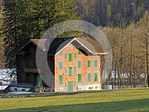 Traditional architecture and farmhouses in the alpine valley of KlÃ¶ntal or Kloental and by the resevoir lake KlÃ¶ntalersee