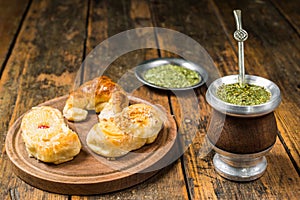 Traditional Argentinian yerba mate tea in calabash gourd and argentine pastries.
