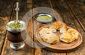 Traditional Argentinian yerba mate tea in calabash gourd and argentine pastries.