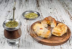 Traditional Argentinian yerba mate tea in calabash gourd and argentine pastries.