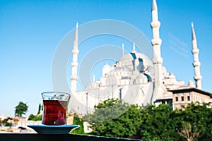 Traditional aromatic Turkish black tea in a tulip-shaped glass. In the background, the Blue Mosque is also called